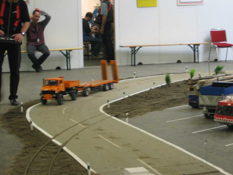 Tractor de carretera gobernado por radiocontrol (persona de la izquierda)