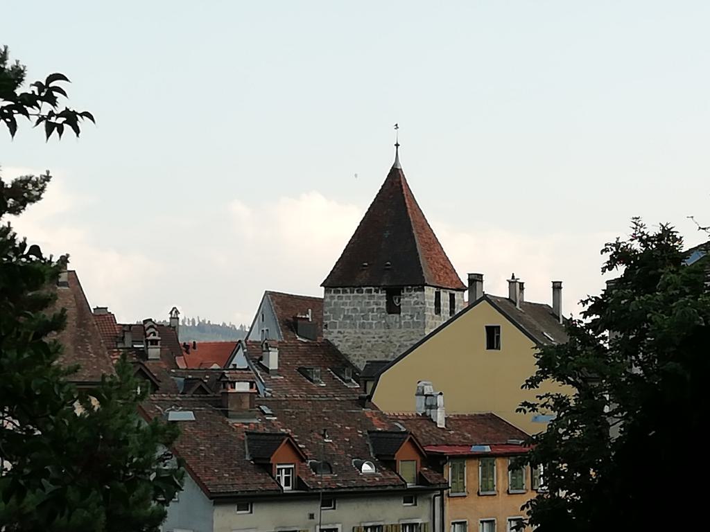 Sobre los tejados se alza la torre antigua de la Altstadtleist Biel