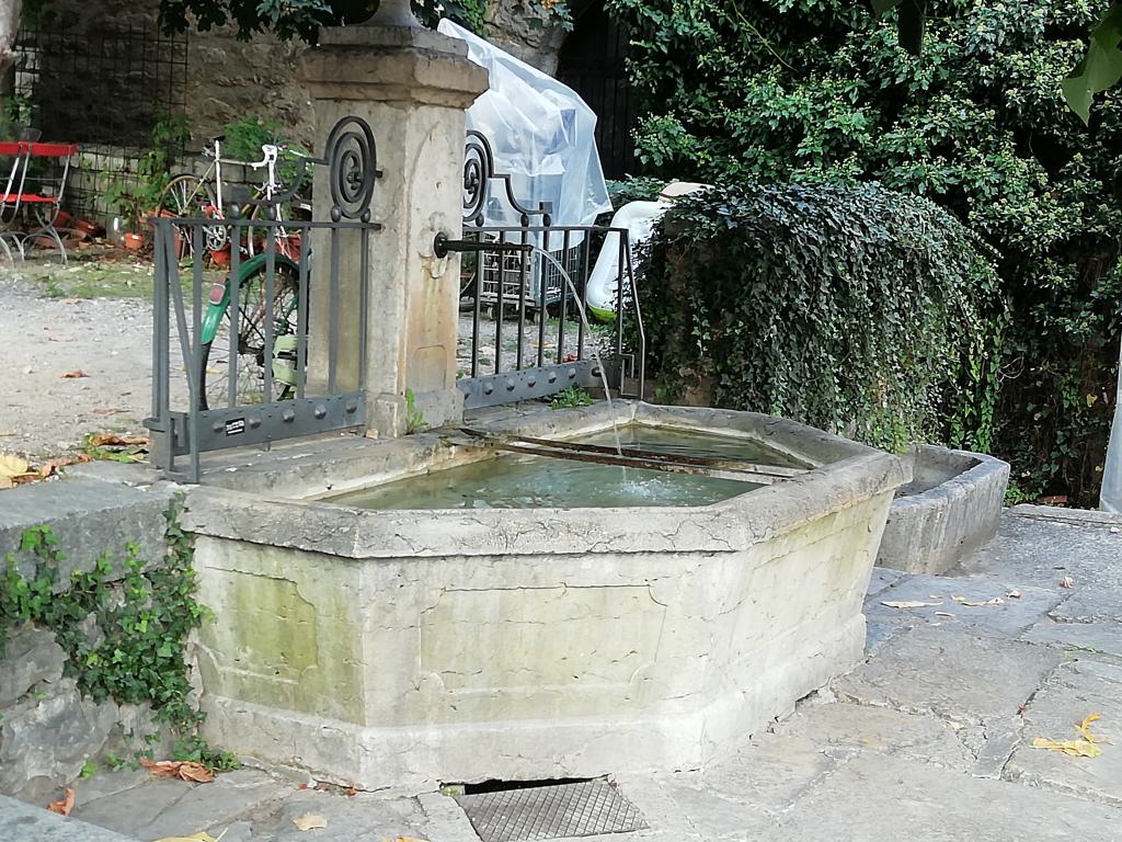 Tìpica fuente con los dos hierros para recoger el agua en un recipiente