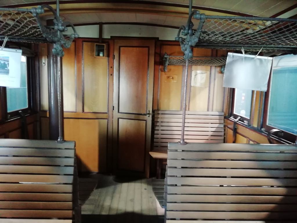 Interior del coche de tercera clase con la chimenea de la estufa puesta tras la puerta