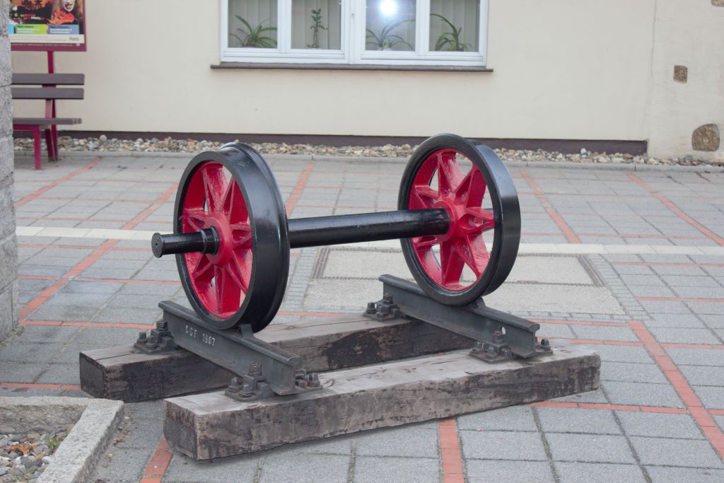 Sobre el patio de vías un monumento al material antiguo, traviesas de madera, soportes combinados para los railes y ruedas de radios